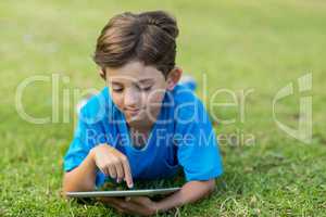 Young boy using digital tablet in park