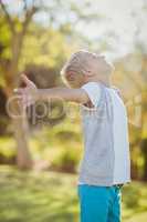 Smiling young boy standing with arms outstretched