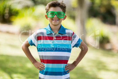 Young boy in shutter shades standing with hand on hip