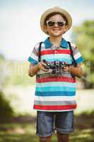Young boy in sunglasses holding a camera