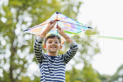 Boy holding a kite in park