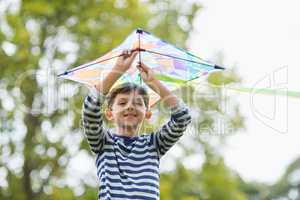 Boy holding a kite in park