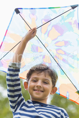 Boy holding a kite in park