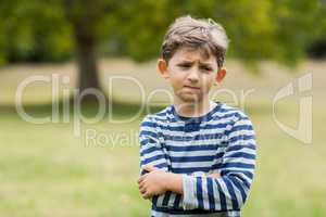 Portrait of upset boy standing with arms crossed