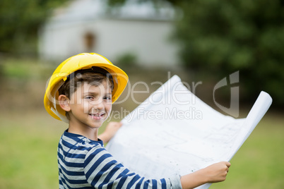 Boy in hard hat holding a plan