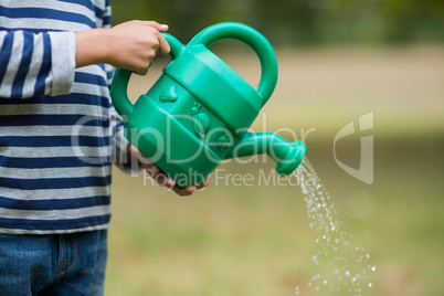 Boy pouring water from watering can