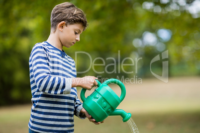 Boy pouring water from watering can