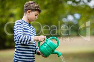 Boy pouring water from watering can