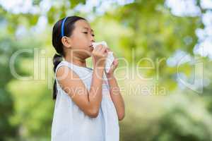 Girl blowing her nose with handkerchief while sneezing