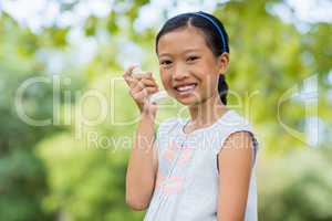 Portrait of girl using an asthma inhaler in the park