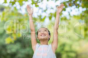 Smiling girl standing with arms raised