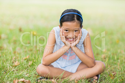 Portrait of smiling girl sitting with hand face