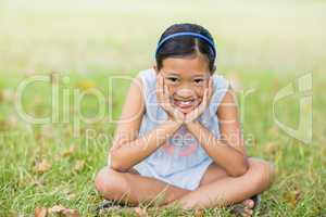 Portrait of smiling girl sitting with hand face