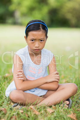 Portrait of upset girl sitting on grass