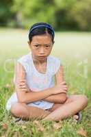 Portrait of upset girl sitting on grass
