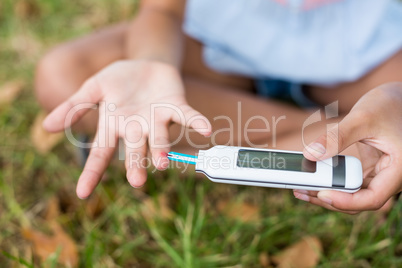 Girl testing diabetes on glucose meter