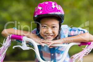 Portrait of smiling girl leaning on a bicycle