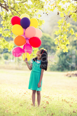 Girl holding a balloon in park