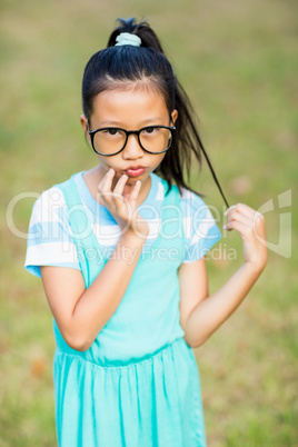 Portrait of girl standing with hand on chin