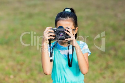 Young girl clicking a photograph from camera