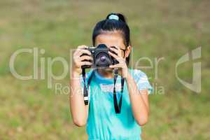 Young girl clicking a photograph from camera