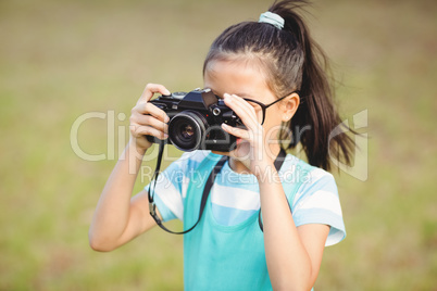 Young girl clicking a photograph from camera