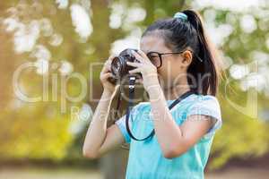 Young girl clicking a photograph from camera