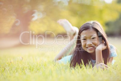 Smiling young girl lying on grass