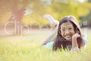 Smiling young girl lying on grass