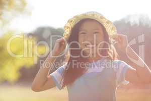 Portrait of young girl wearing hat smiling in park
