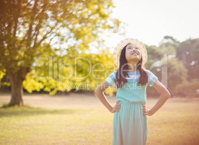 Smiling girl standing with hand on hip in park