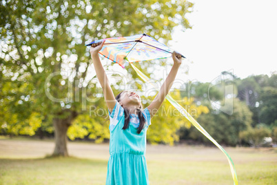 Girl holding a kite in park