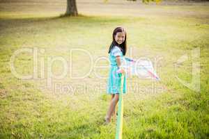 Portrait of smiling girl playing with kite in park