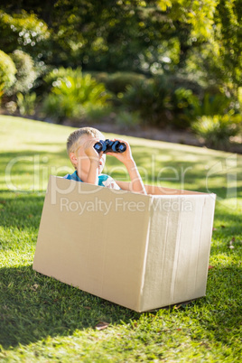 Young boy looking through binoculars in park