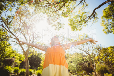 Girl standing with arms outstretched in park