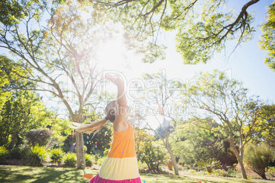 Girl standing with arms outstretched in park