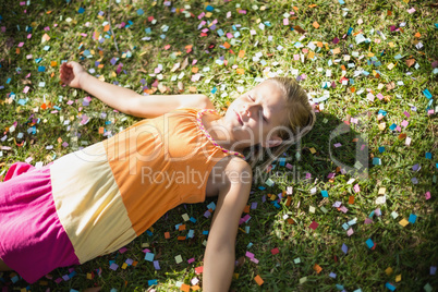 Cute young girl lying on grass in park