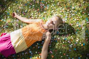 Cute young girl lying on grass in park