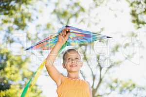 Smiling girl holding kite in park