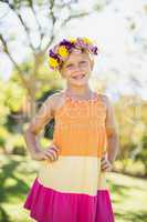 Portrait of girl wearing wreath standing with hand on hip