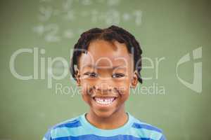Portrait of happy schoolboy smiling in classroom