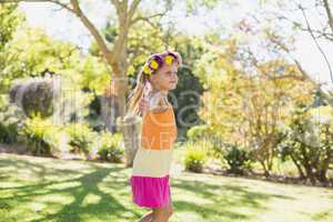 Girl wearing wreath standing with arms outstretched in park