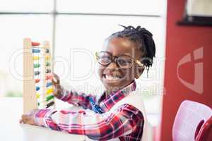 Schoolgirl using a maths abacus at school