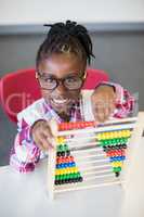 Schoolgirl using a maths abacus at school