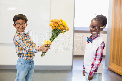 Schoolboy giving a bunch of flowers to a schoolgirl