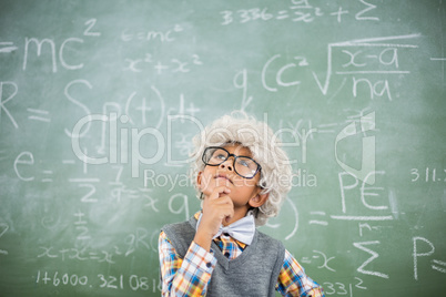 Thoughtful schoolboy wearing wig in classroom