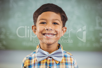 Portrait of happy schoolboy smiling in classroom