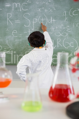 Schoolboy solving mathematics on chalkboard in classroom