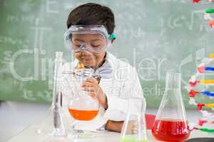 Schoolboy doing a chemical experiment in laboratory