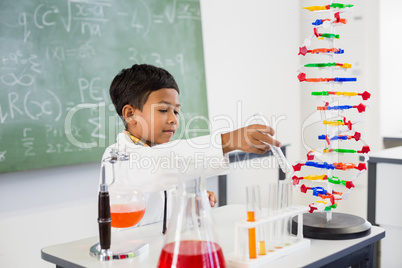 Schoolboy doing a chemical experiment in laboratory